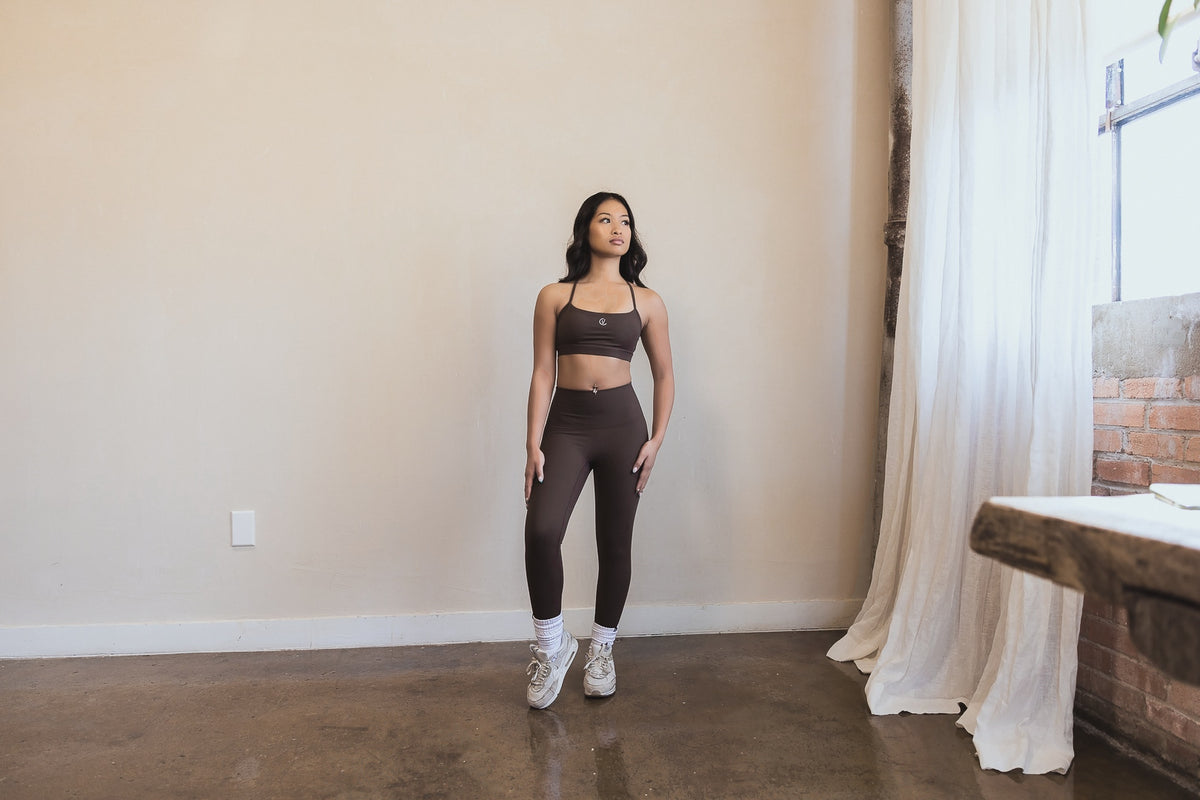 Certavibe model in a warm brown activewear set, calm studio light